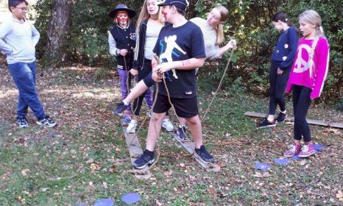 A group of children are playing a game in the woods.