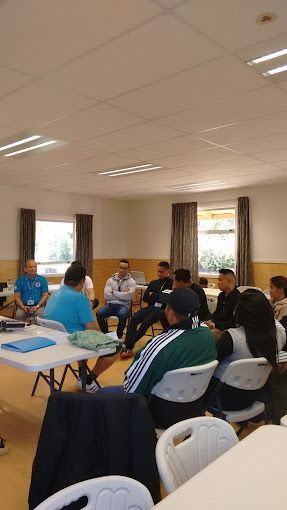 A group of people are sitting at a table with laptops.