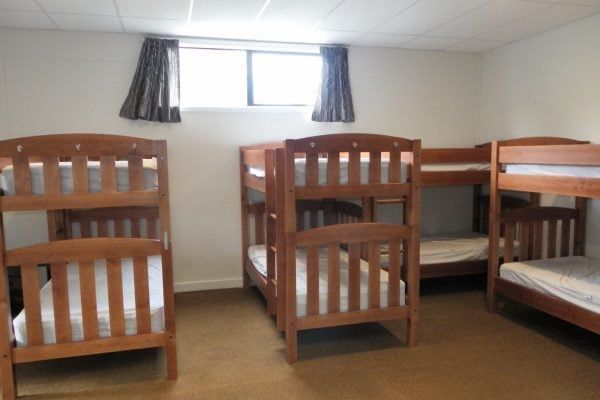 A room with four bunk beds and a window