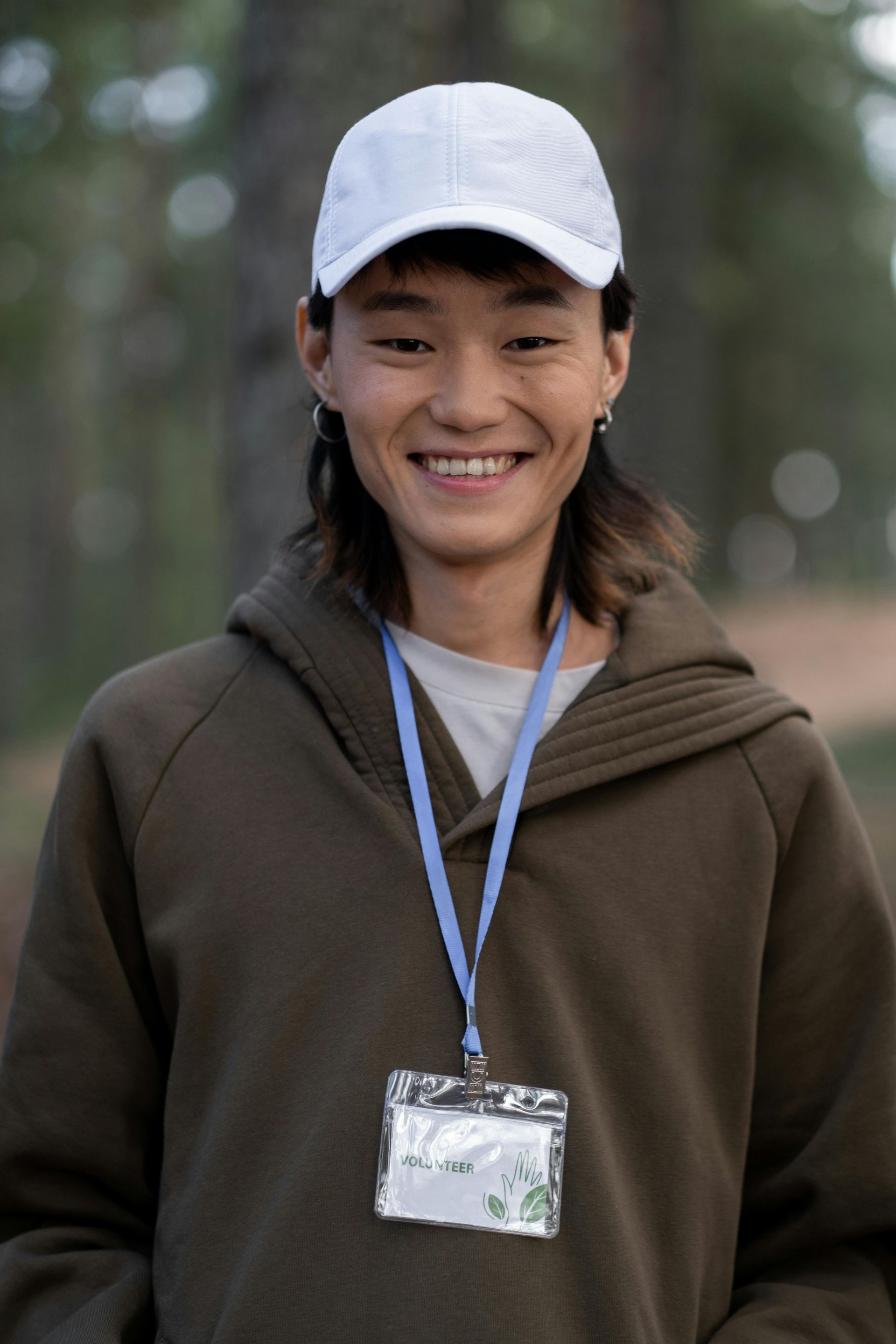 A woman wearing a white hat and a name tag is smiling.