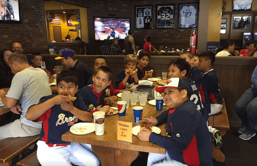 Kids sports team enjoying pizza inside Lamppost