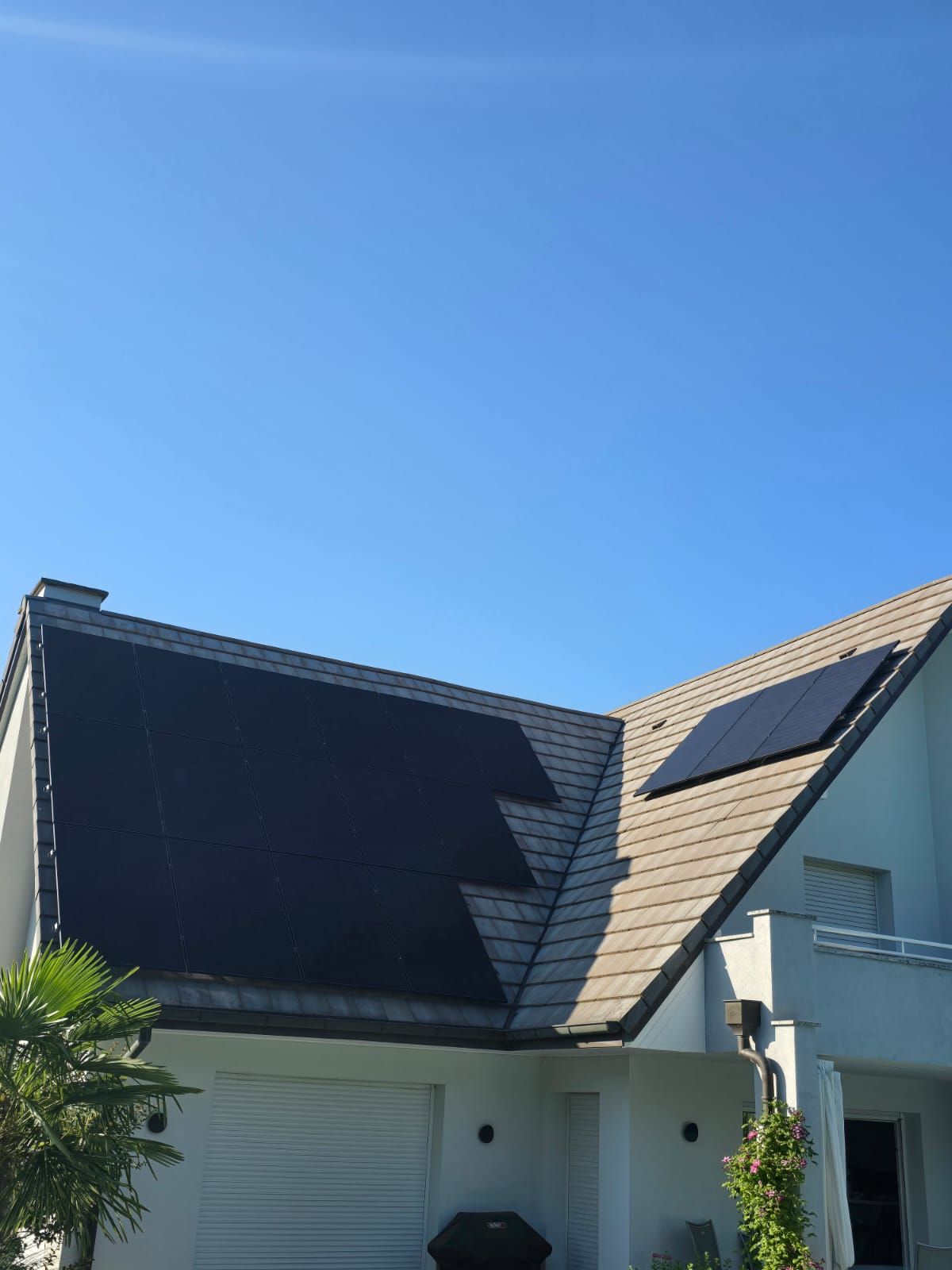 Une maison blanche avec des panneaux solaires sur le toit