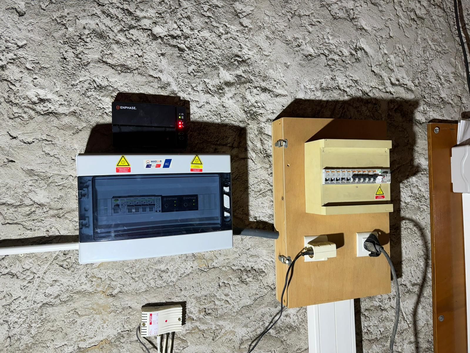 Deux boîtiers électriques sont posés sur un mur l'un à côté de l'autre.