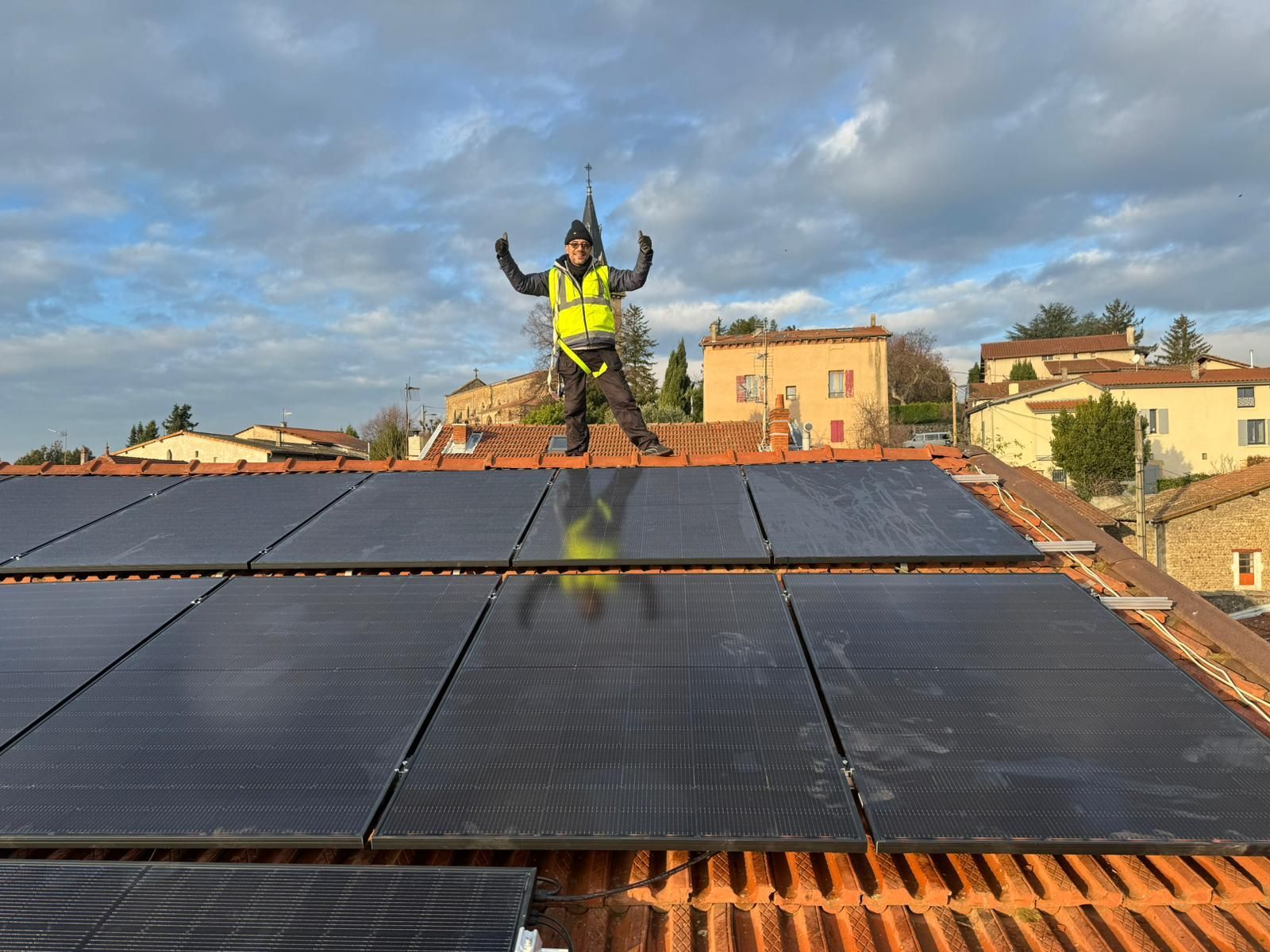 Un homme se tient debout sur un toit avec des panneaux solaires.