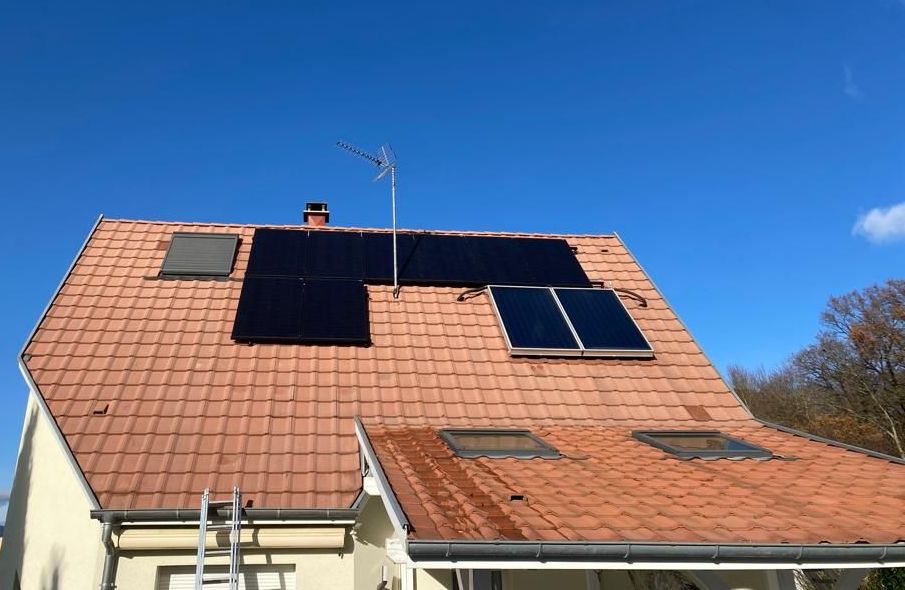 Une maison avec des panneaux solaires sur le toit et une échelle.
