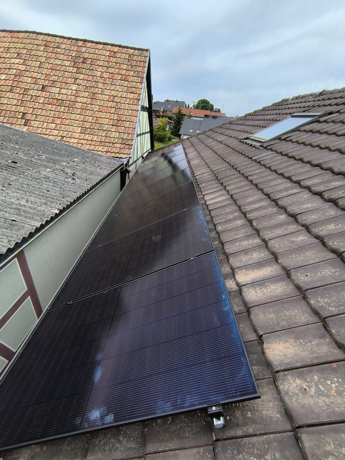 Une rangée de panneaux solaires posés sur un toit en tuiles.