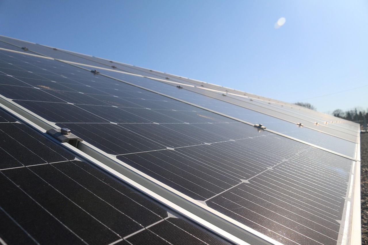 Panneaux solaires sur un toit, orientés vers le soleil par une journée claire et bleue.