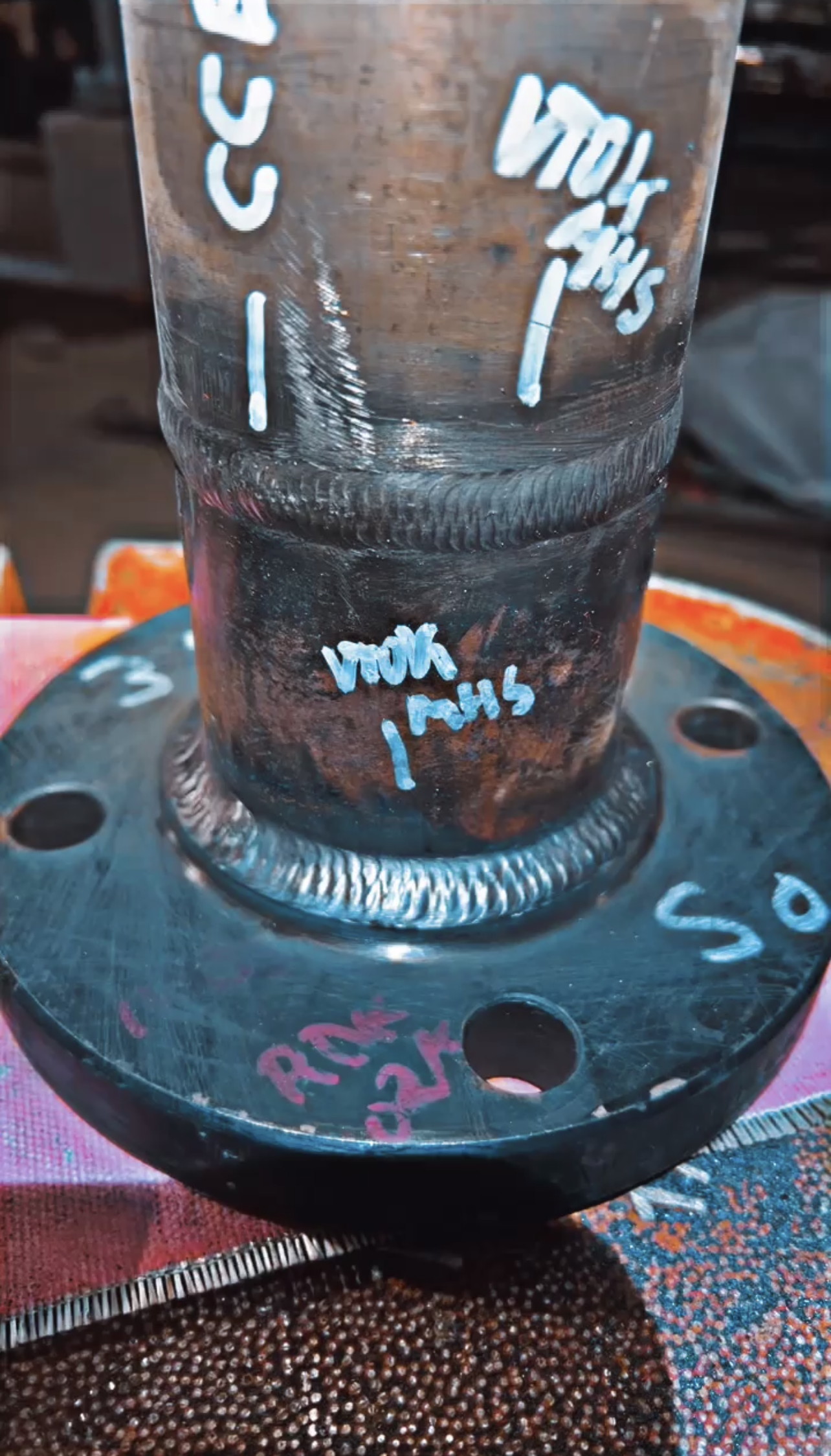 Steel pipe with welded flange; blue writing.