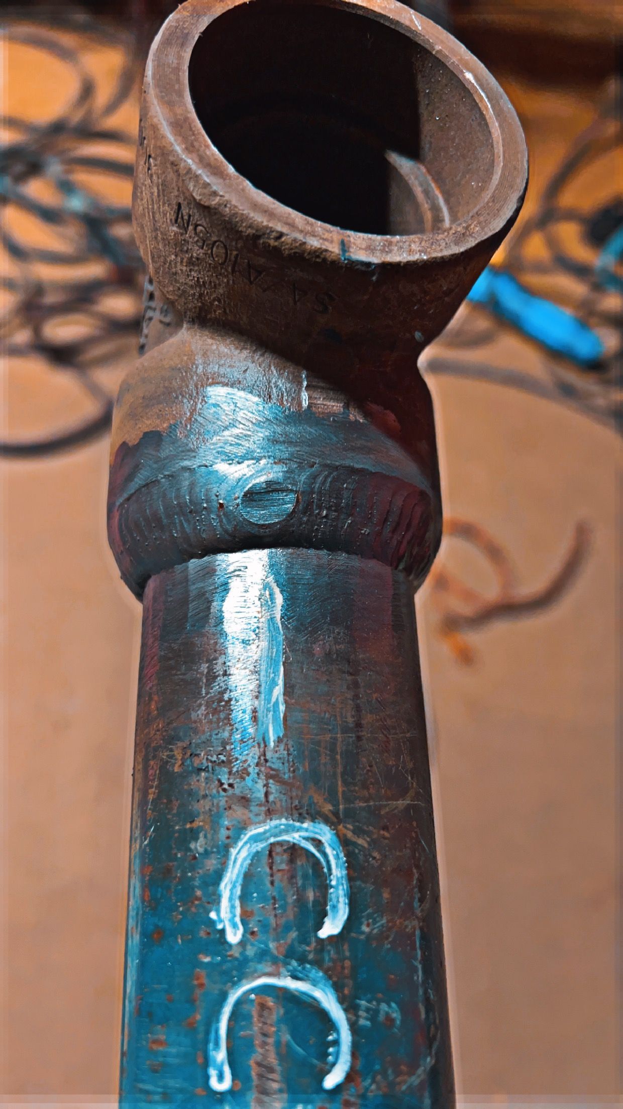 Close-up of a dark metal pipe with a 45-degree angle.