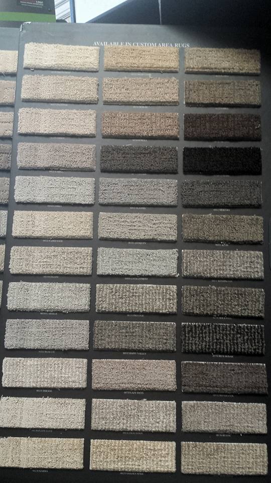 A variety of carpet samples are displayed on a table.