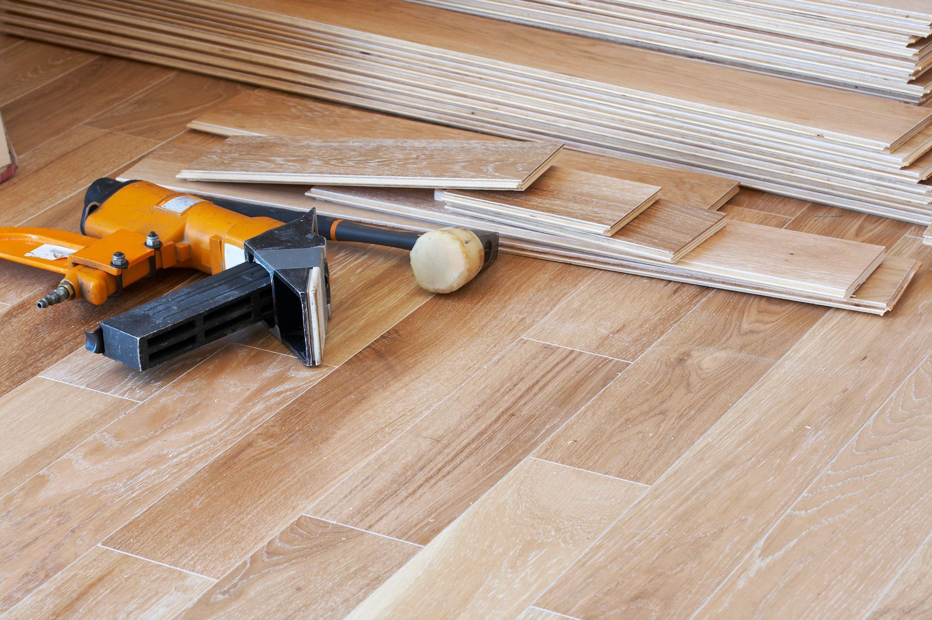 Hardwood flooring planks with installation tools on a newly laid floor