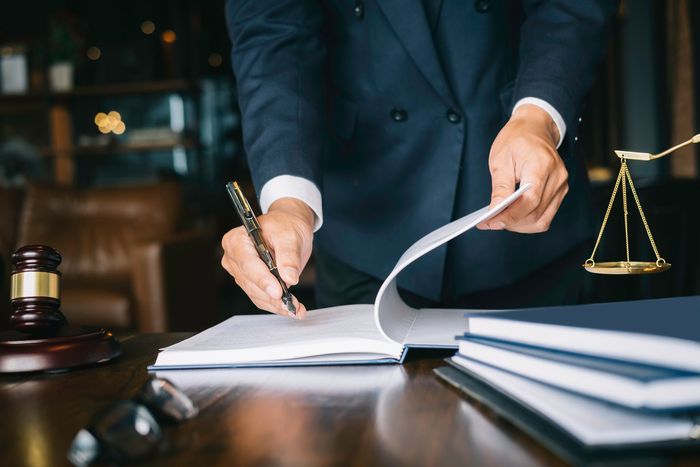 a man in a suit is writing on a piece of paper