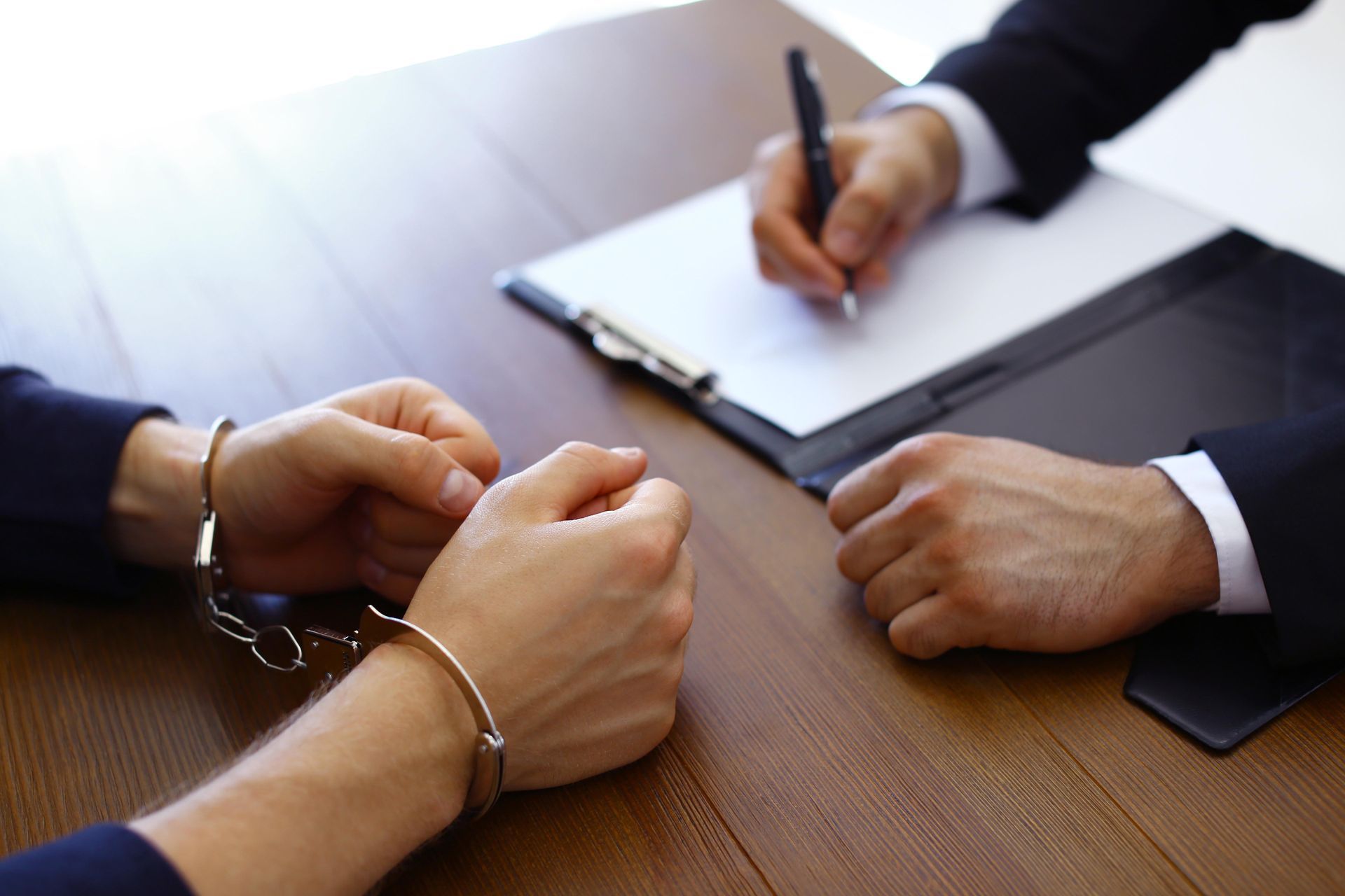 a man and a woman in handcuffs are sitting at a table