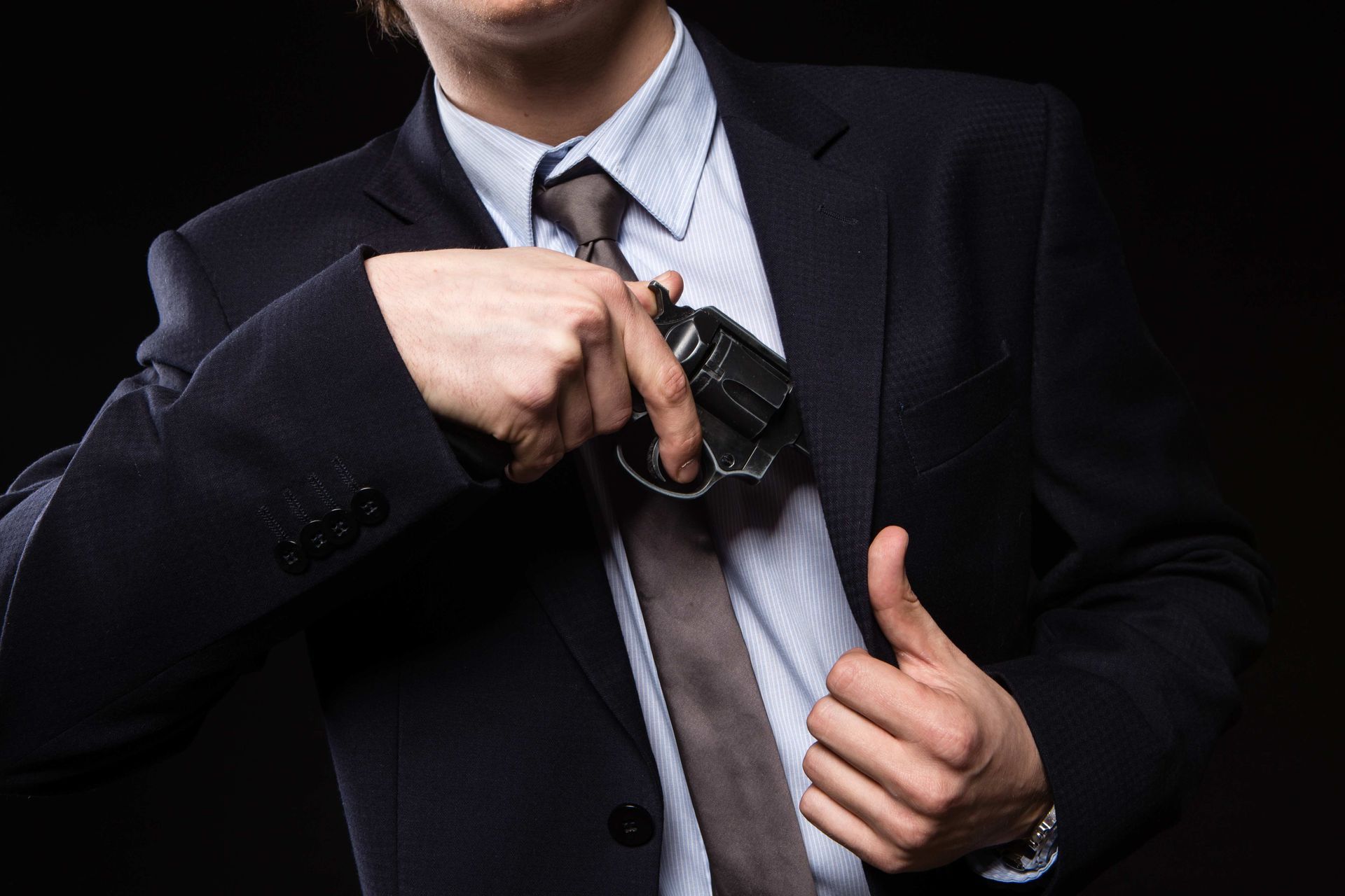 man in suit holding gun