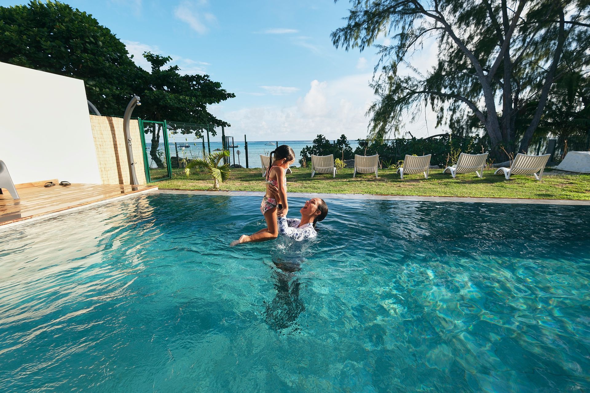 A man is holding a woman in his arms in a swimming pool.
