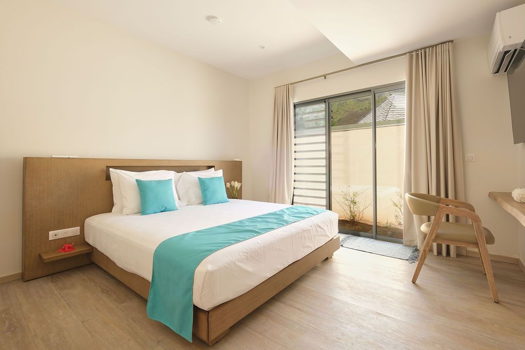 A hotel room with a king size bed and a chair