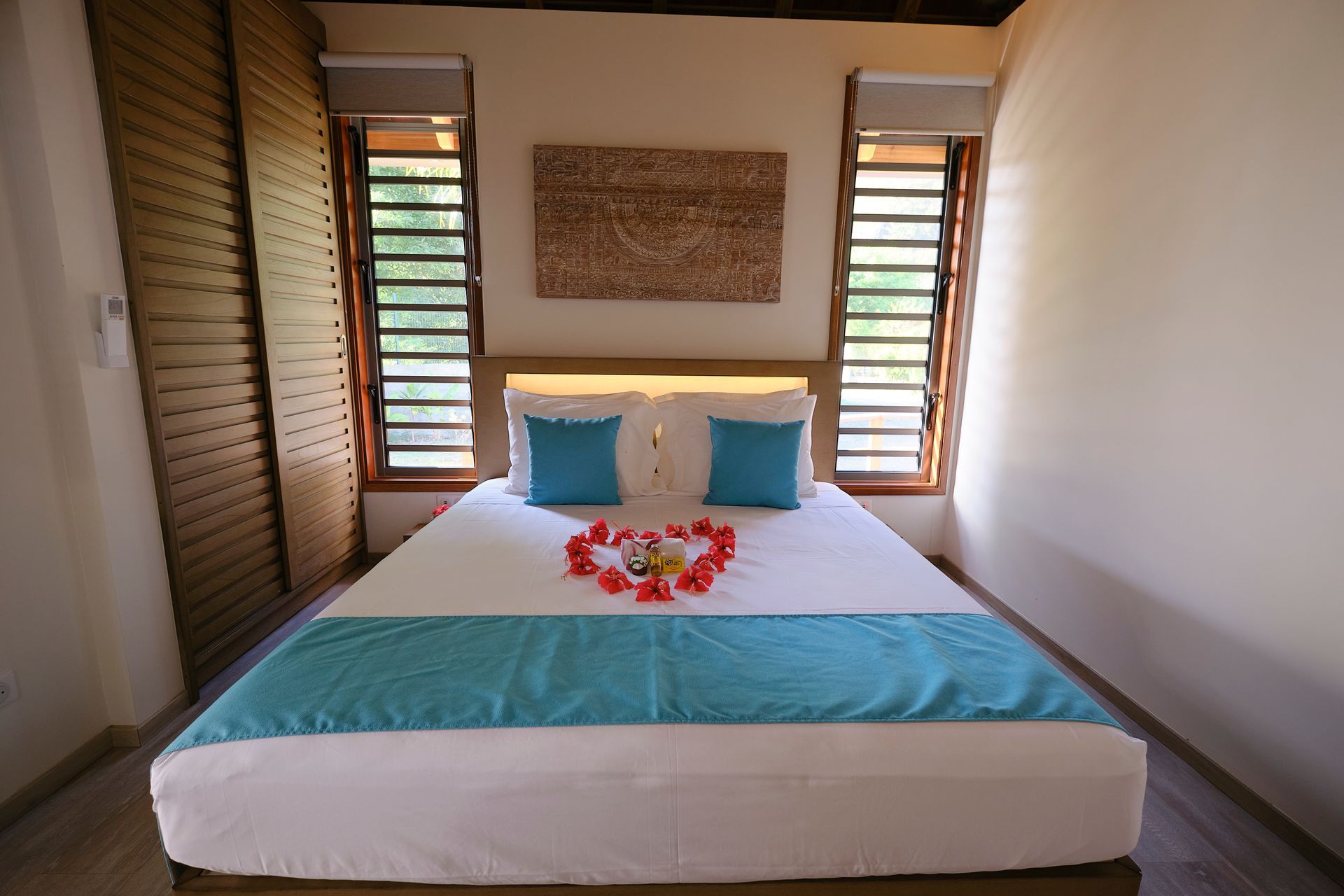 A bedroom with a large bed and two windows.