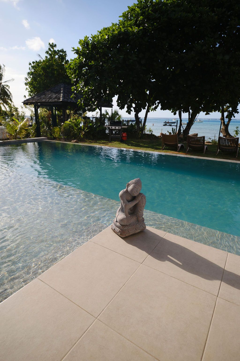 A statue sits on the edge of a swimming pool