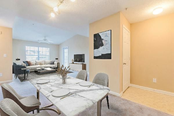 Gray kitchen with black appliances, white subway tile backsplash, and a window.