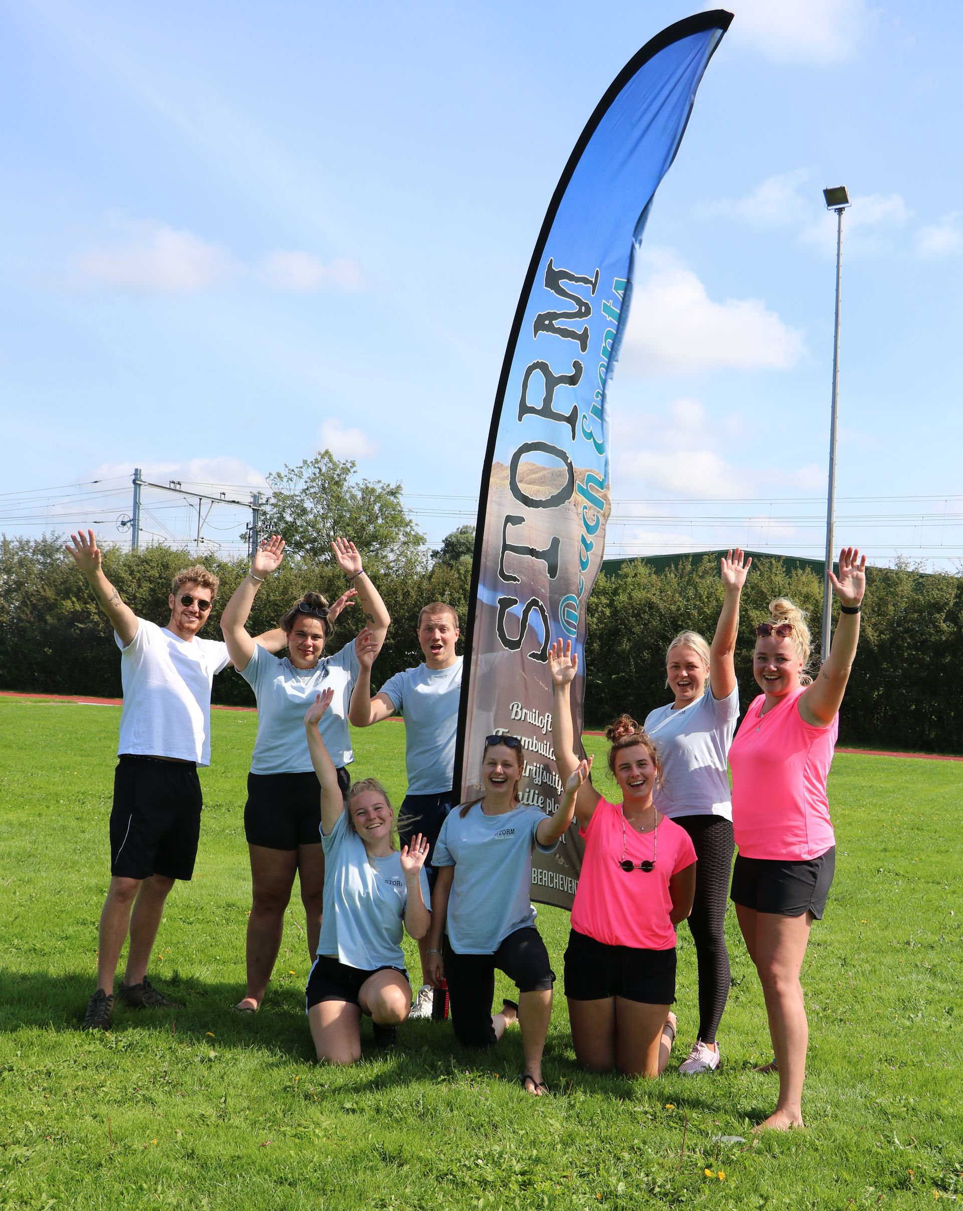 Een groep mensen viert feest op een grasveld met een 