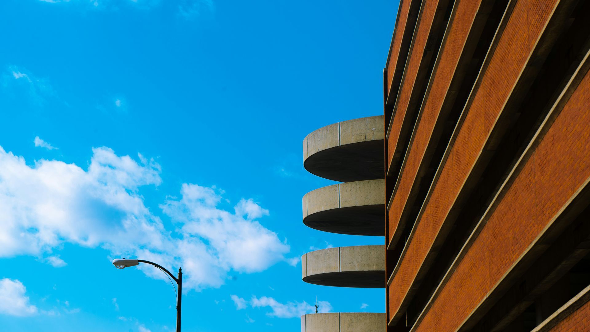 Two people in suits shaking hands at a table, documents and laptop present.