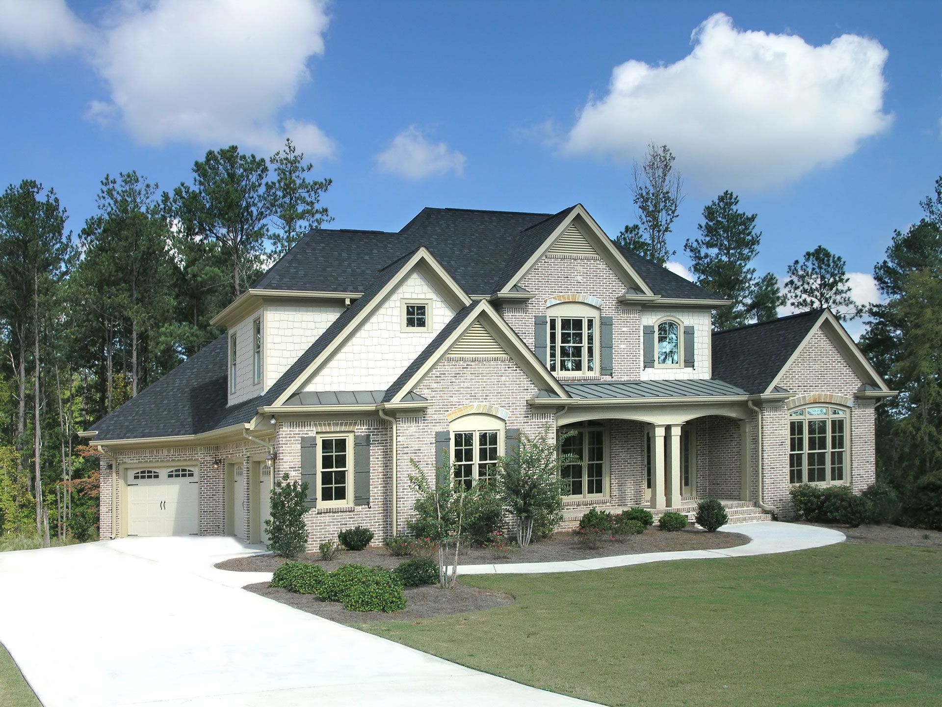 A large white brick house with a black roof