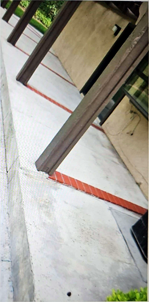 A concrete walkway with a red stripe on the side of it
