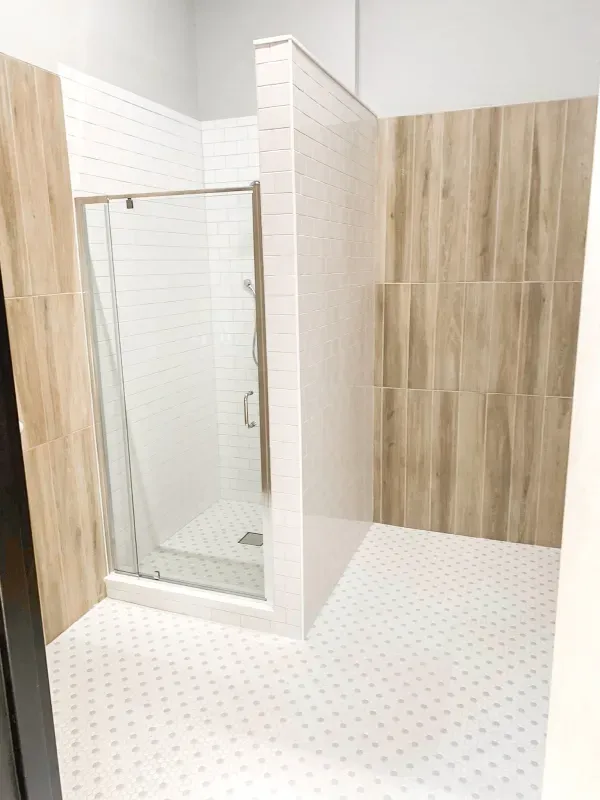 A bathroom with a walk in shower and wooden walls.