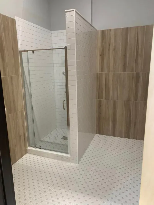 A bathroom with a walk in shower and wooden walls.