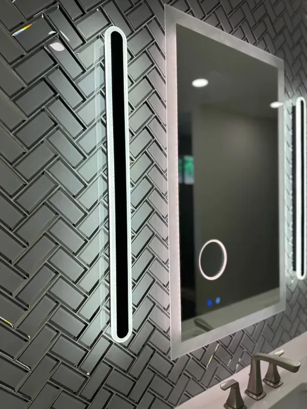 A bathroom mirror with a herringbone pattern on the wall