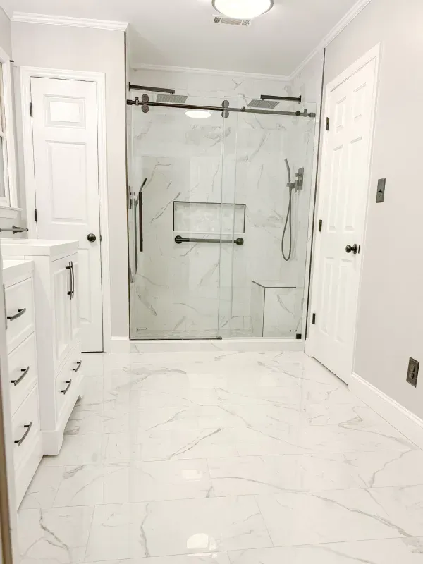 A bathroom with a walk in shower and a sink.