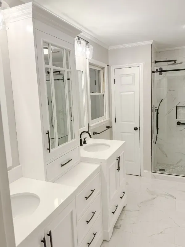A bathroom with two sinks and a walk in shower.