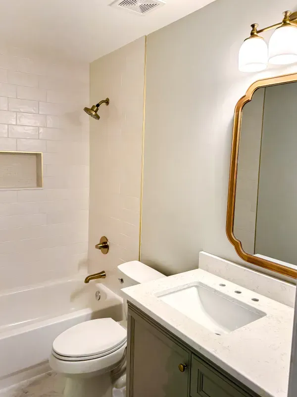 A bathroom with a toilet , sink , bathtub and mirror.