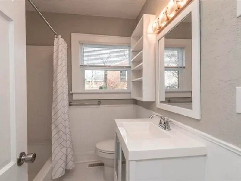 A bathroom with a toilet , sink and mirror