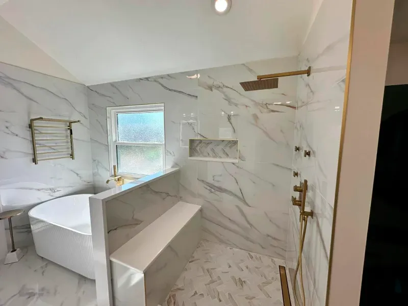 A bathroom with a tub , shower , and window.