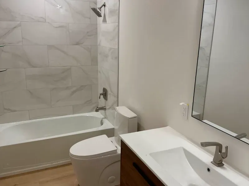 A bathroom with a toilet , sink and bathtub.
