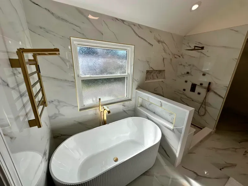 A bathroom with a bathtub , toilet , shower and window.