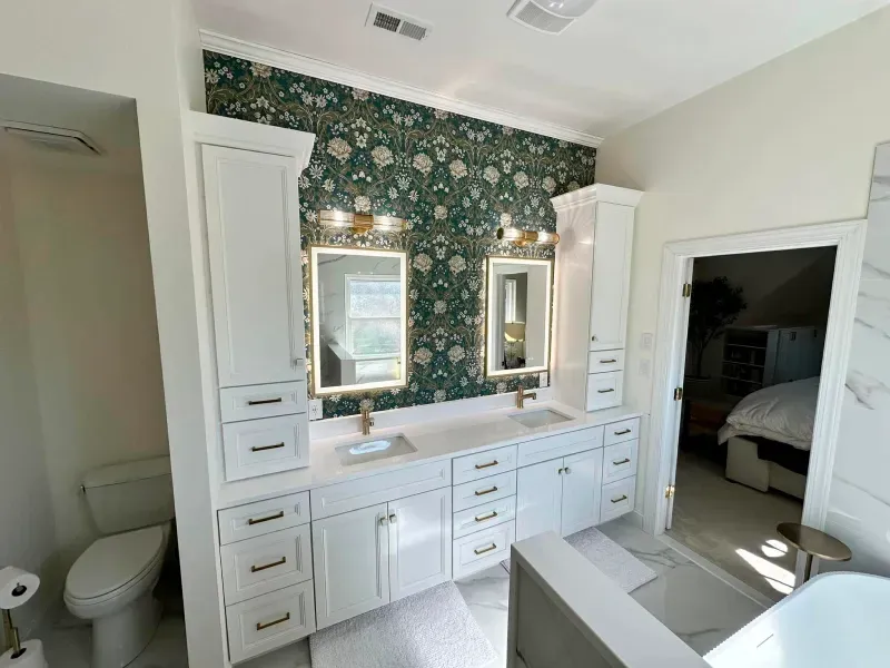 A bathroom with two sinks , a toilet , and two mirrors.