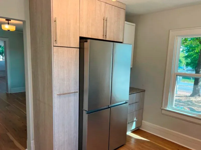 A kitchen with stainless steel appliances and wooden cabinets.