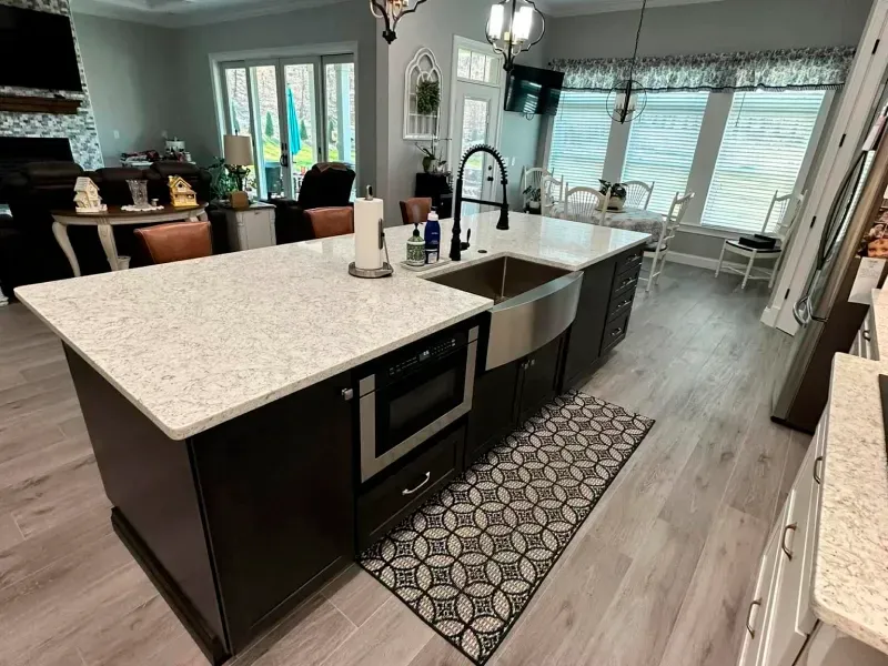 A kitchen with a large island and a stainless steel sink.