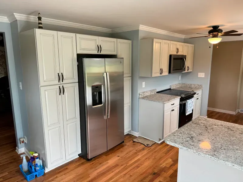 A kitchen with stainless steel appliances and white cabinets.