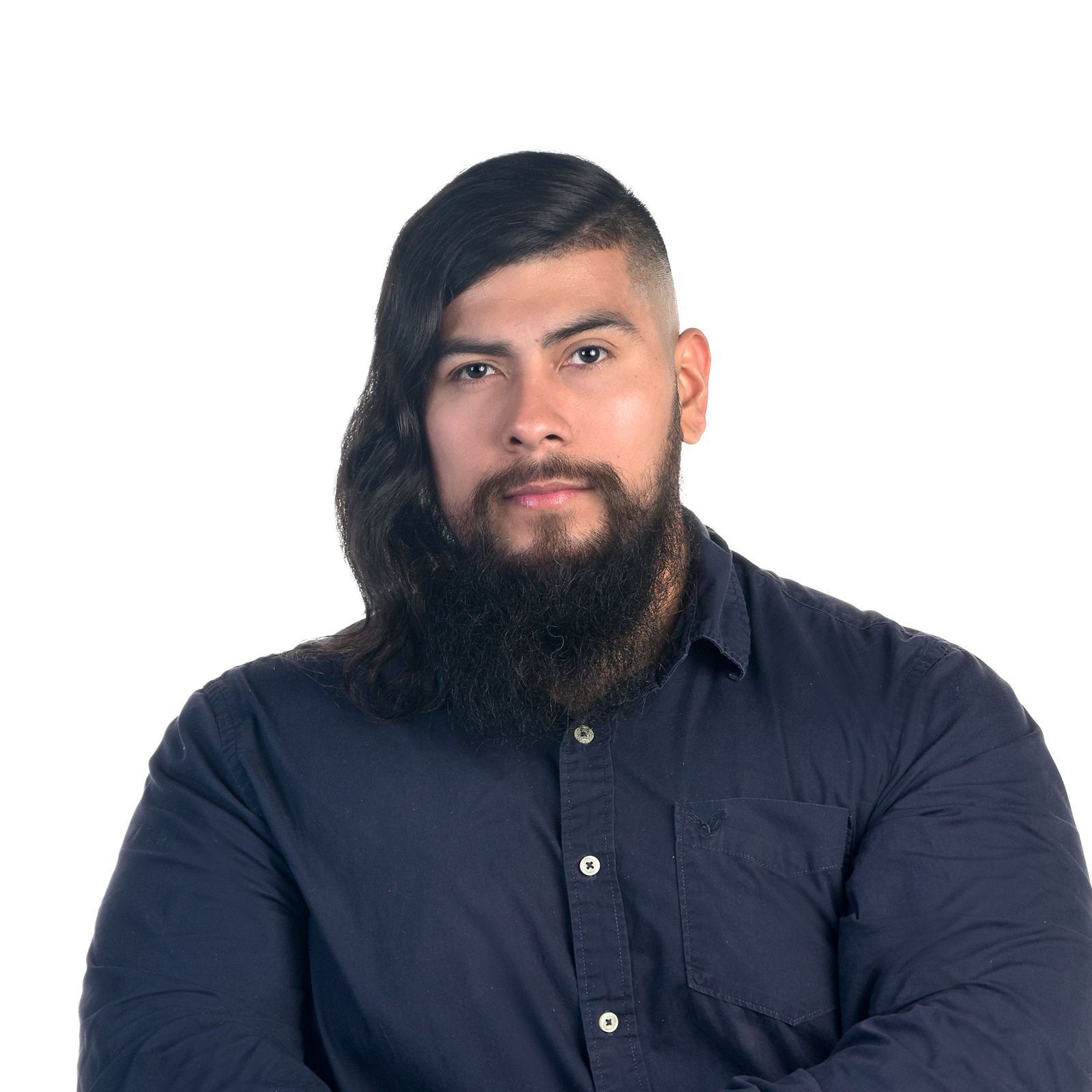 A man with a beard and long hair is wearing a blue shirt