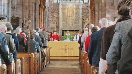People attending church service, with altar in background.