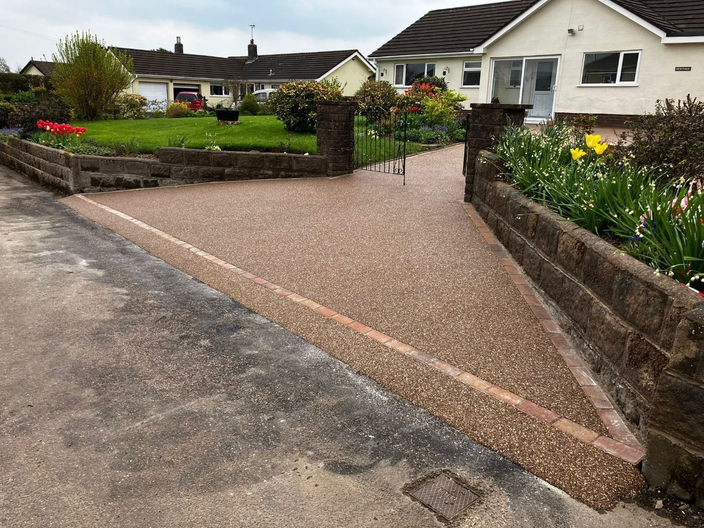 A picture of our work on a gold coloured resin driveway, with orange and red blocks for the borders.