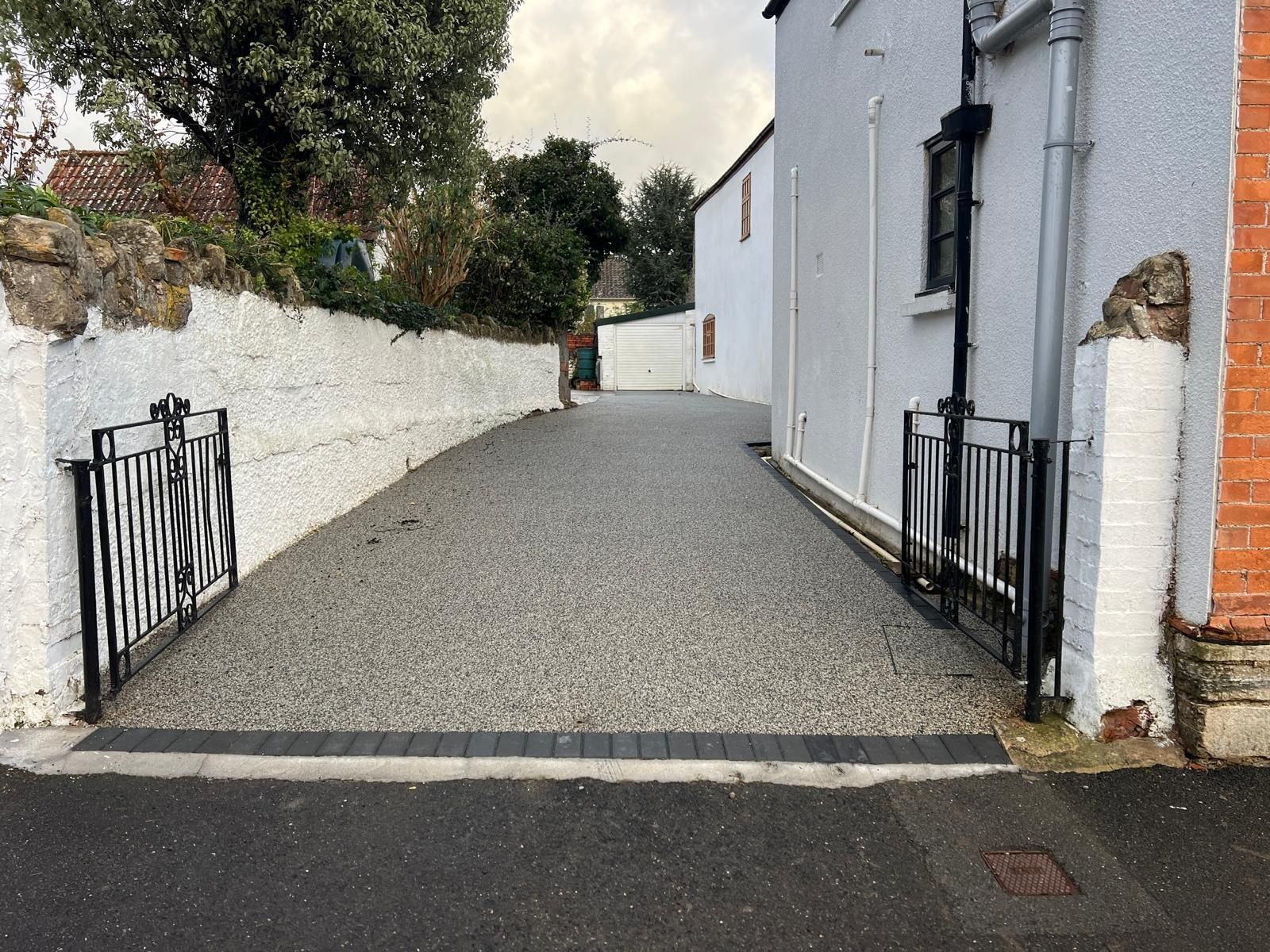 A gravel driveway leading to a white building