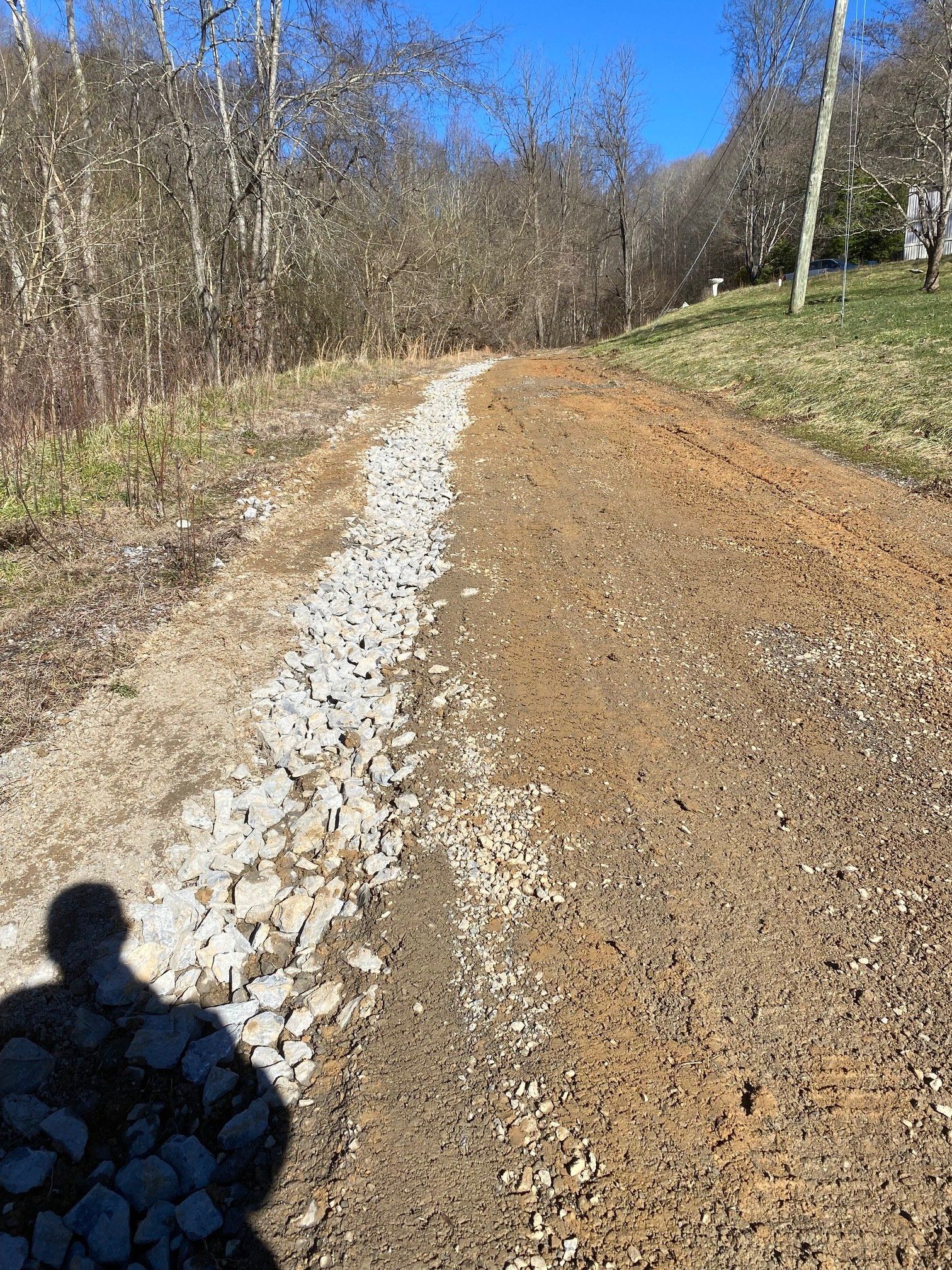 A dirt road with a lot of rocks on the side of it.