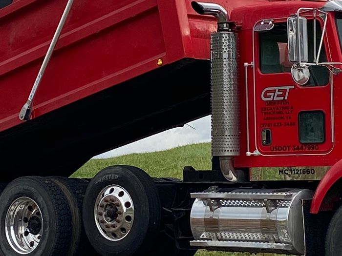 A red dump truck with the word get on the side