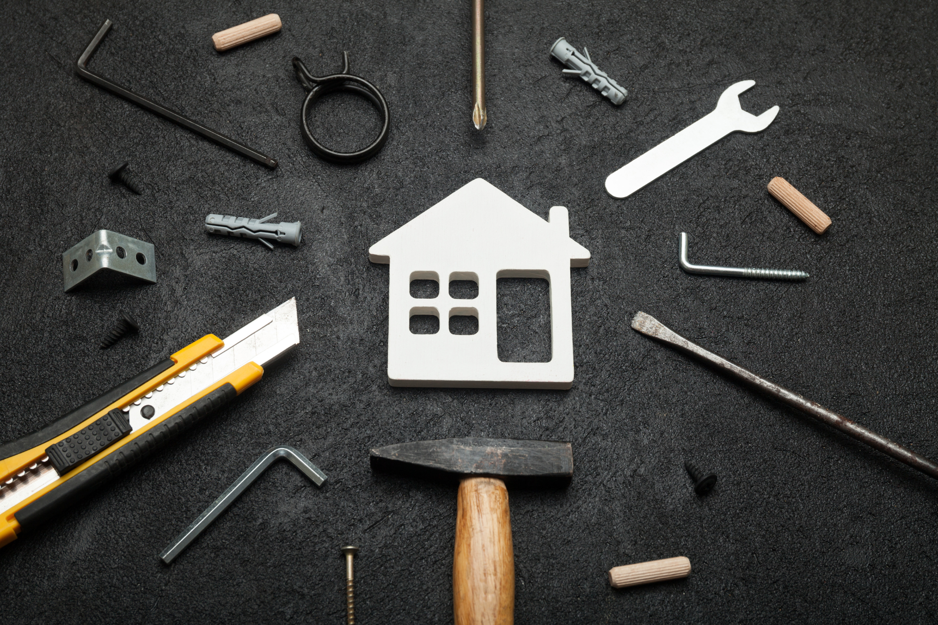 There is a model of a house surrounded by tools.