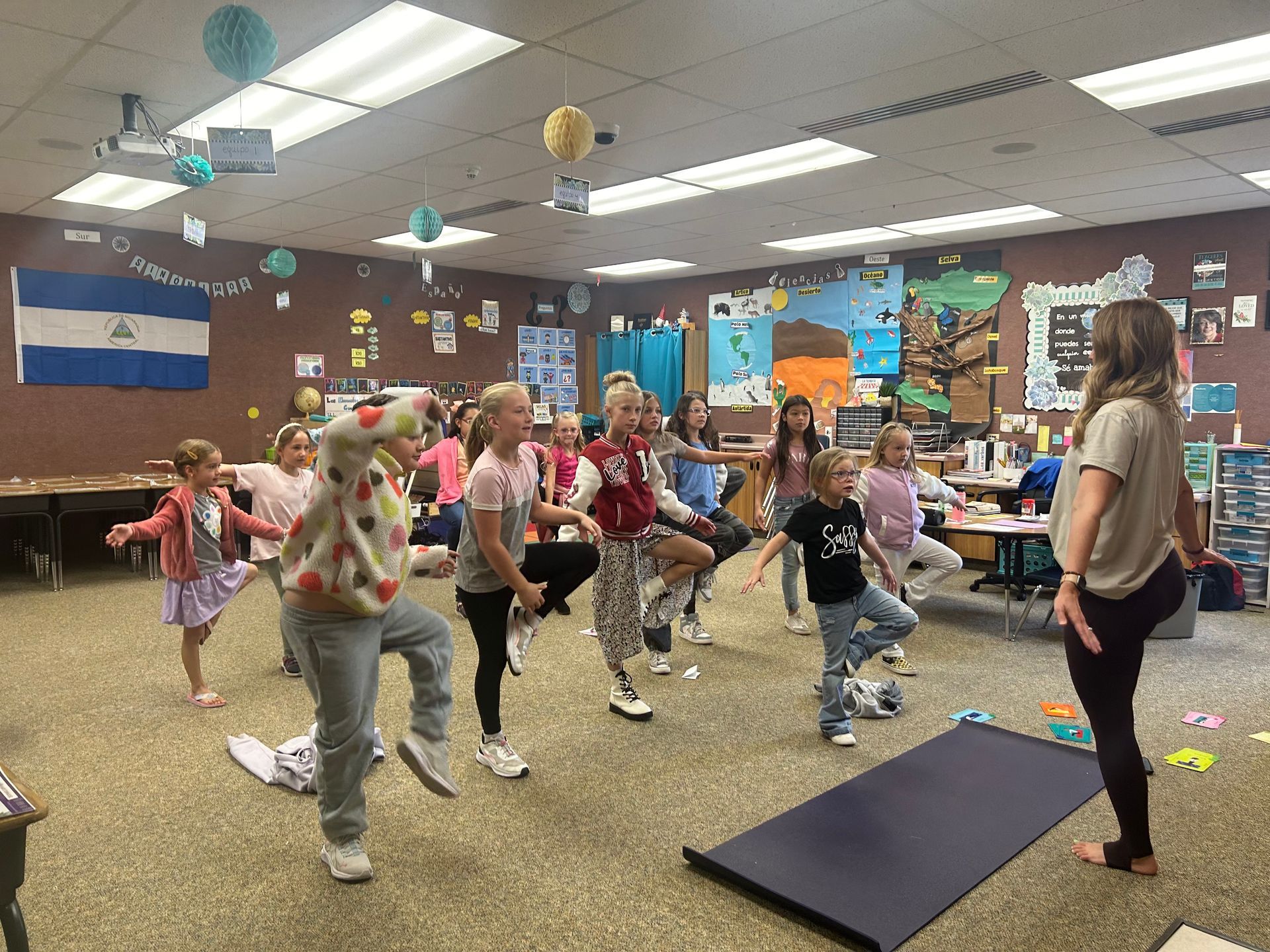 A group of students performing yoga in their classroom.