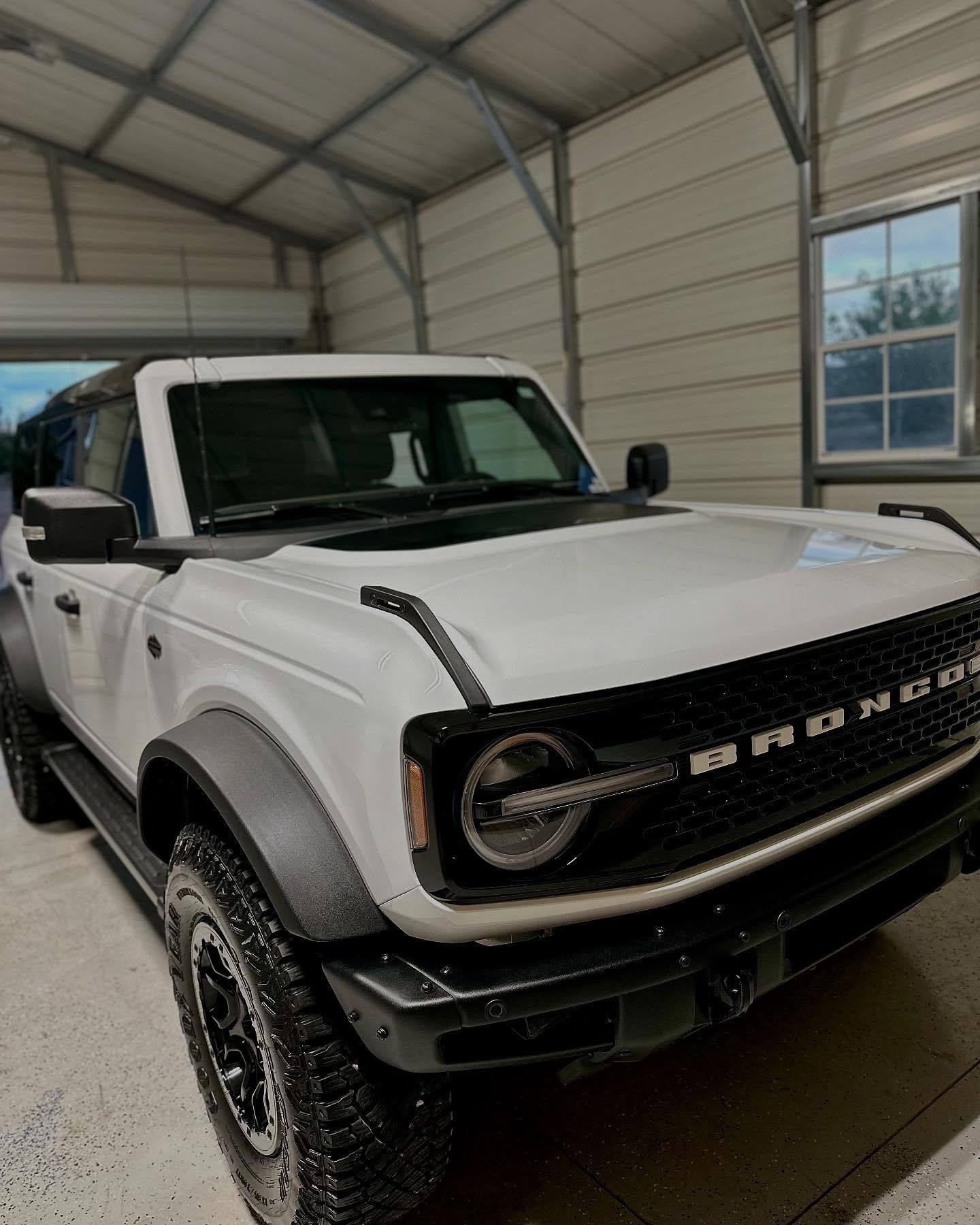 White Ford Bronco parked inside a garage.
